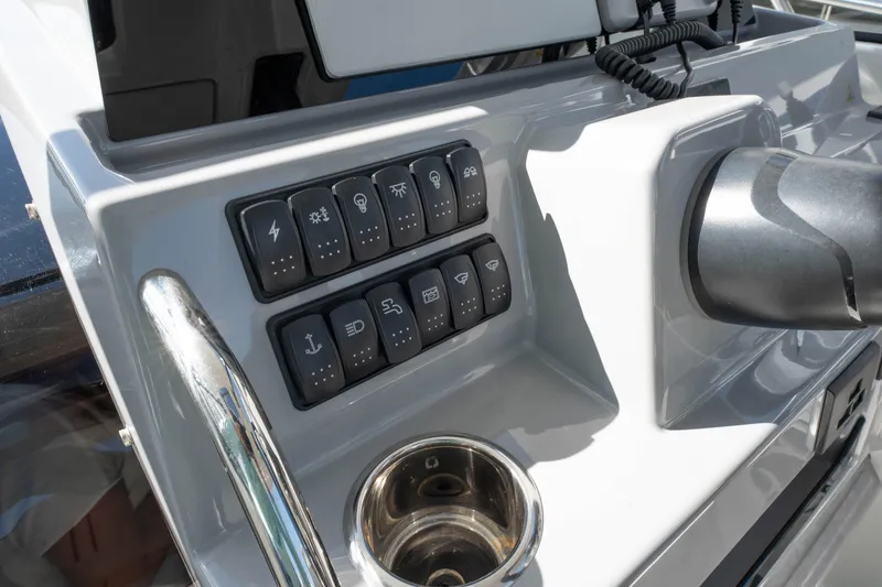Slide: The Image of Control panel of 2024 Jeanneau Leader 9.0WA S2 boat with switches and cup holder. - 31