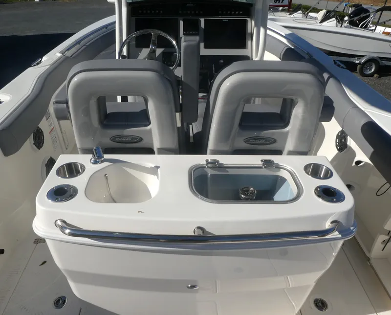 Slide: The Image of 2024 Boston Whaler 280 Outrage boat interior with helm and seating area. - 14