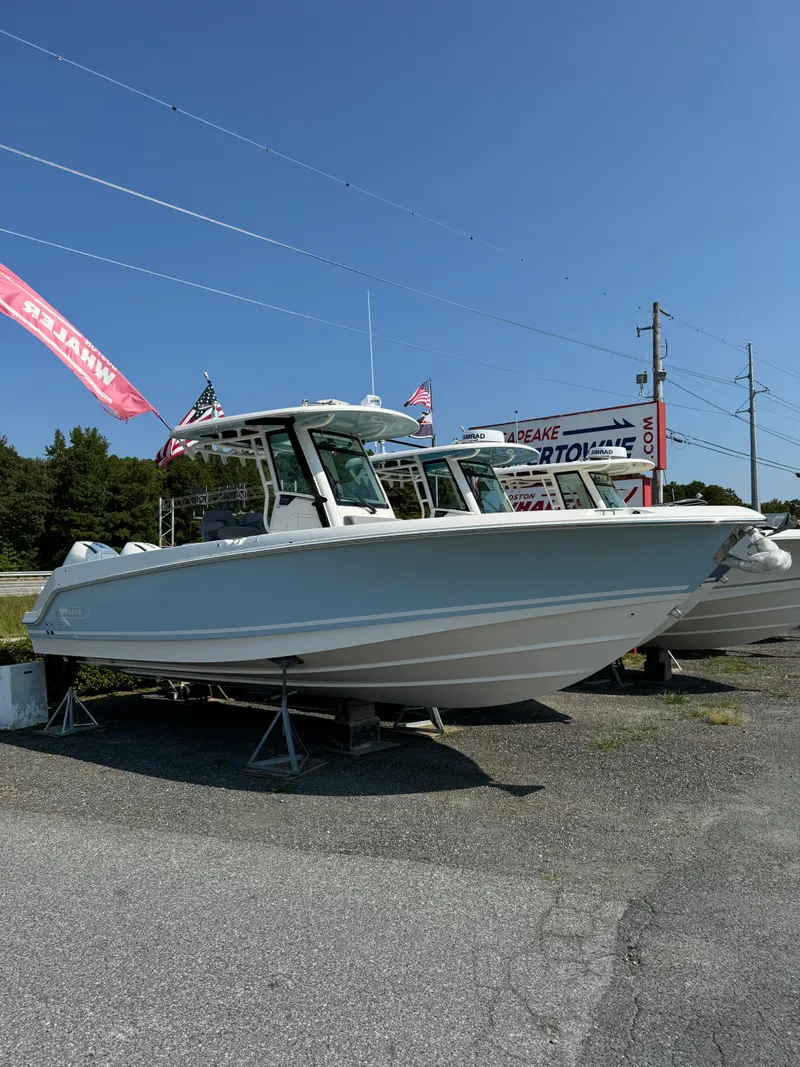 Slide: The Image of 2024 Boston Whaler 280 Outrage boat displayed outdoors on a sunny day. - 2