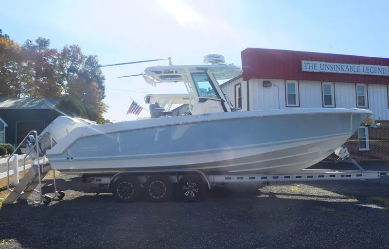 Slide: The Image of 2024 Boston Whaler 280 Outrage boat on trailer, parked outside dealership. - 3