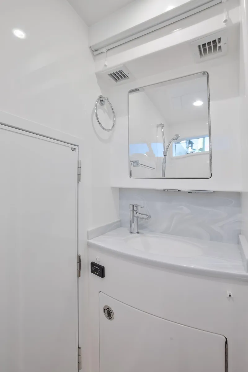 Slide: The Image of 2022 Valhalla Boatworks 46 Center Console interior bathroom with modern sink and mirror. - 20