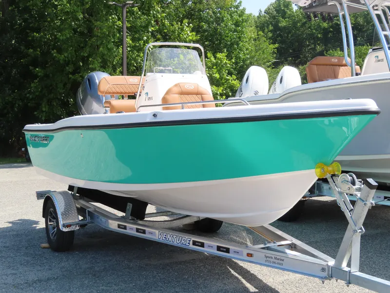 Slide: The Image of 2025 Key West 179 FS boat on trailer, vibrant teal color, parked outdoors. - 1