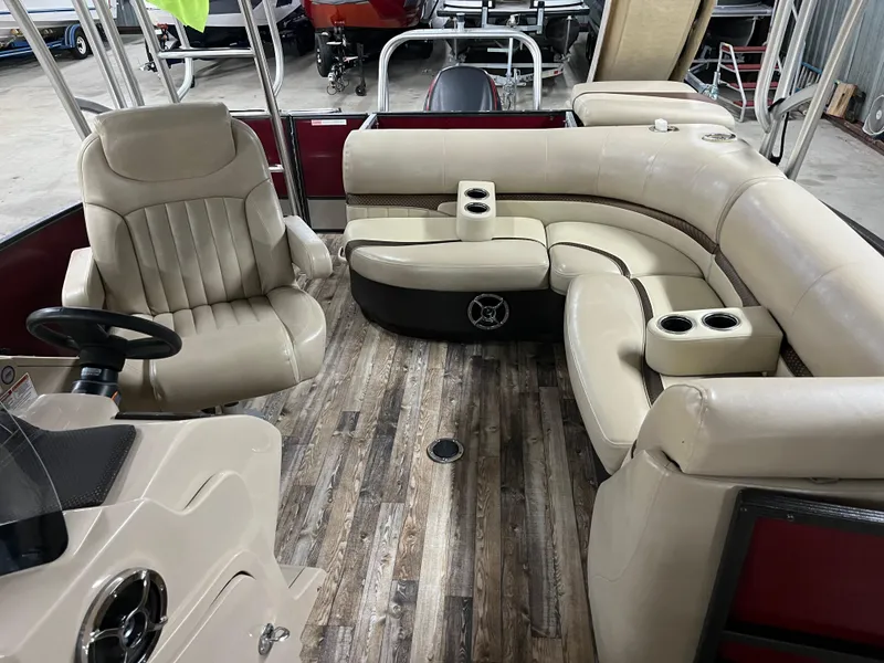 Slide: The Image of 2016 Crest 250 L pontoon boat interior with beige seating and wood-style flooring. - 2