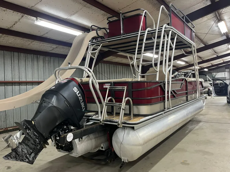 Slide: The Image of 2016 Crest 250 L pontoon boat with slide and Suzuki outboard motor in a storage facility. - 4
