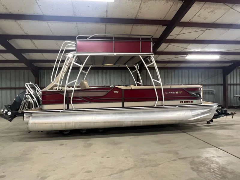 Slide: The Image of 2016 Crest 250 L pontoon boat in a warehouse, featuring a red and silver design. - 5