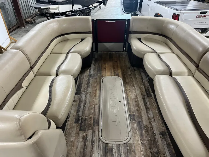 Slide: The Image of 2016 Crest 250 L boat interior with beige seating and wood flooring. - 7