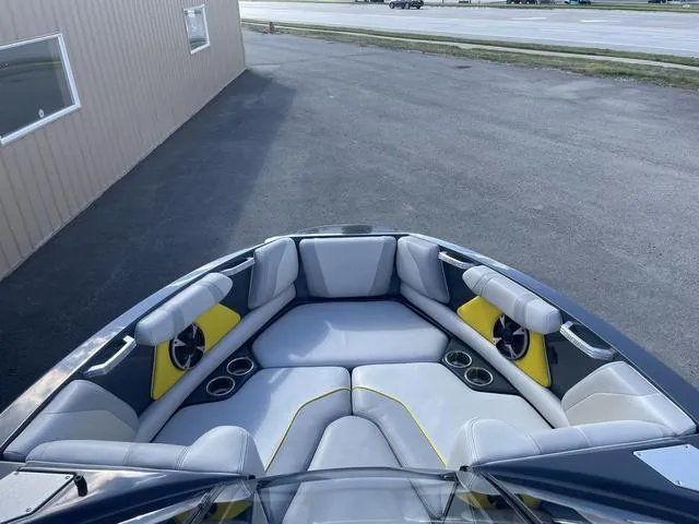 Slide: The Image of 2017 Malibu 21 VLX boat interior with gray and yellow seating, cup holders, and sleek design. - 10