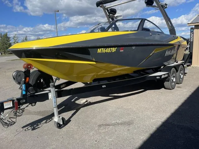 Slide: The Image of 2017 Malibu 21 VLX boat in yellow and black on a trailer, parked outdoors. - 5