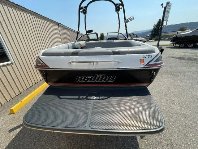 Slide: The Image of 2005 Malibu Sunsetter XTi boat, rear view with swim platform, parked outdoors. - 3