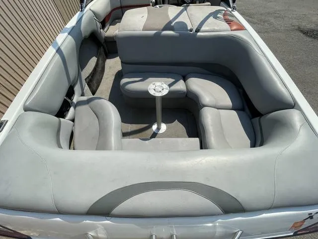 Slide: The Image of 2005 Malibu Sunsetter XTi boat interior with gray seating and a small table. - 5