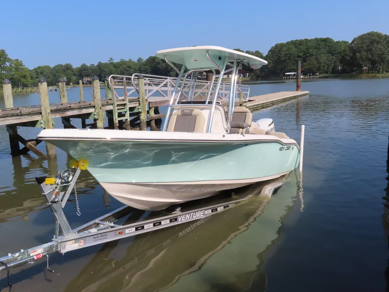 Slide: The Image of 2024 Key West 203 FS boat on trailer at dockside, calm water, clear sky. - 21