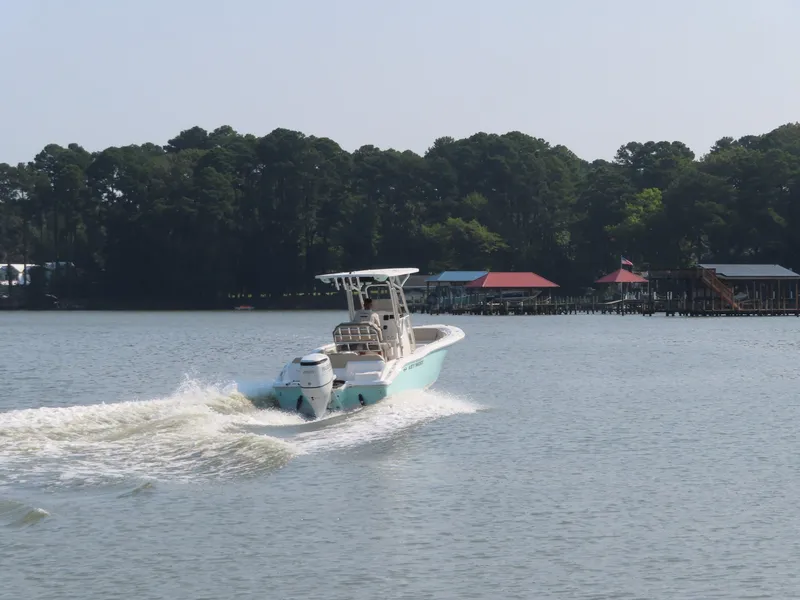 Slide: The Image of 2024 Key West 203 FS boat cruising on a serene lake with forested shoreline. - 26