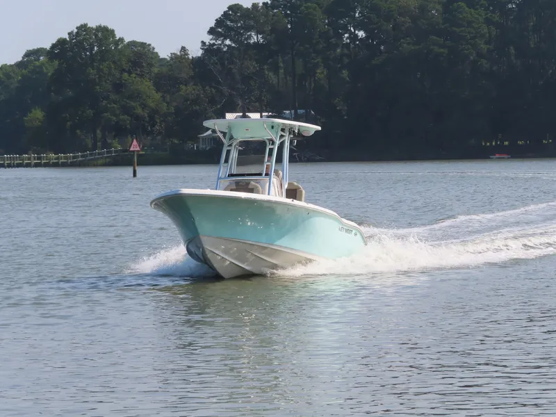 Slide: The Image of 2024 Key West 203 FS boat cruising on a calm lake with forested shoreline. - 33