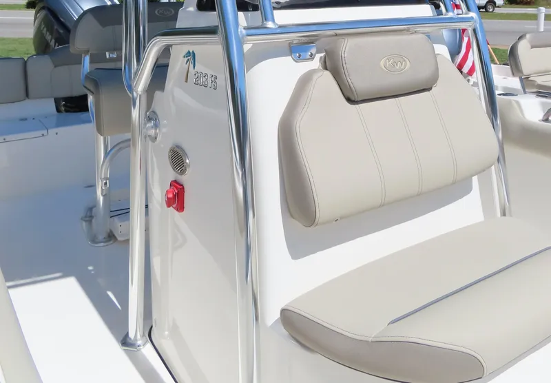 Slide: The Image of 2024 Key West 203 FS boat interior with beige seating and stainless steel details. - 8