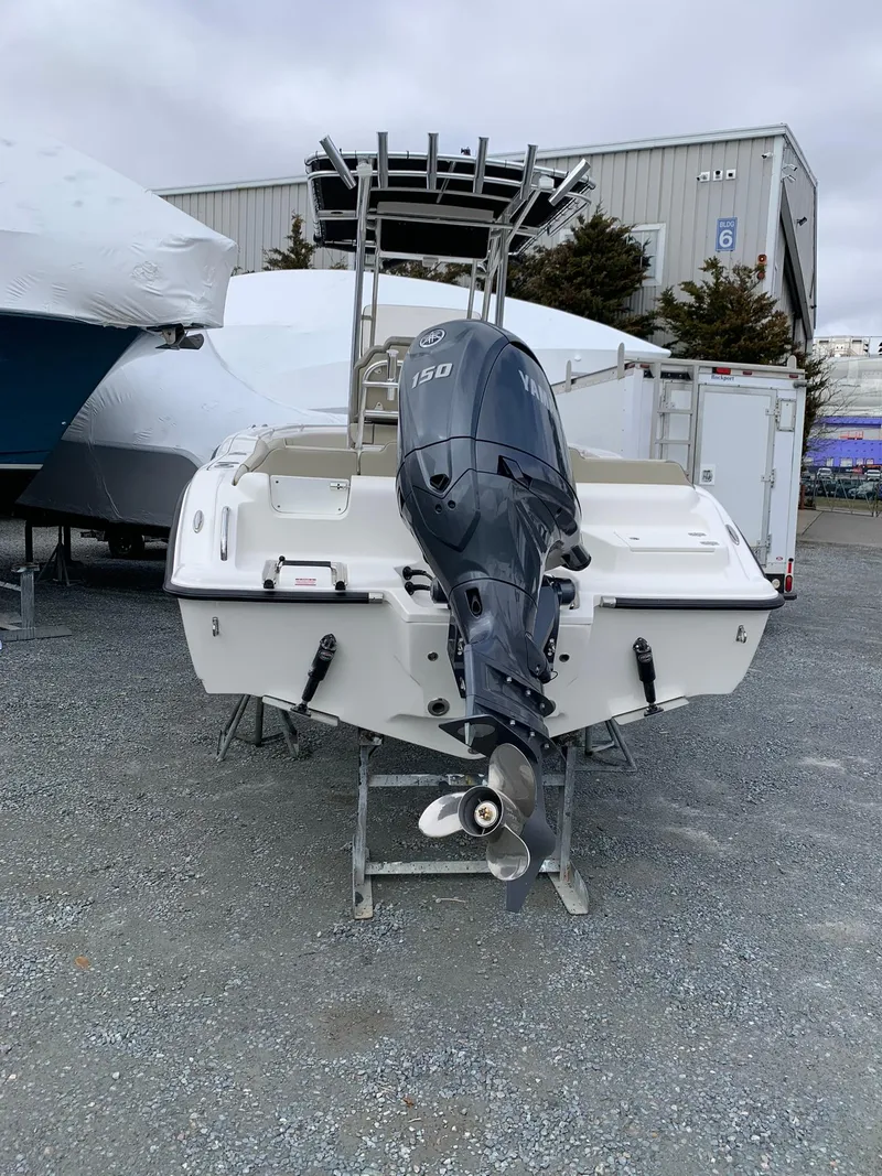 Slide: The Image of 2025 Key West 203 FS boat with Yamaha 150 outboard motor, parked outdoors. - 4