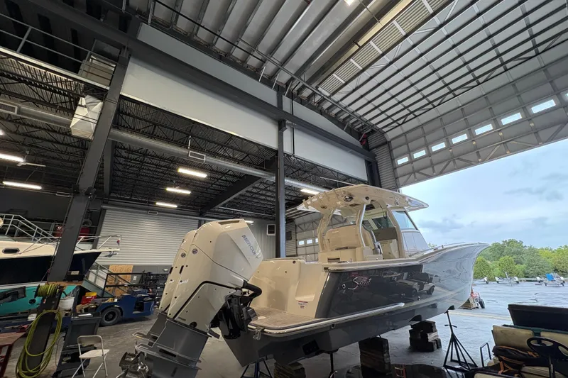 Slide: The Image of 2026 Scout 330 LXF boat in a showroom, showcasing sleek design and modern features. - 2