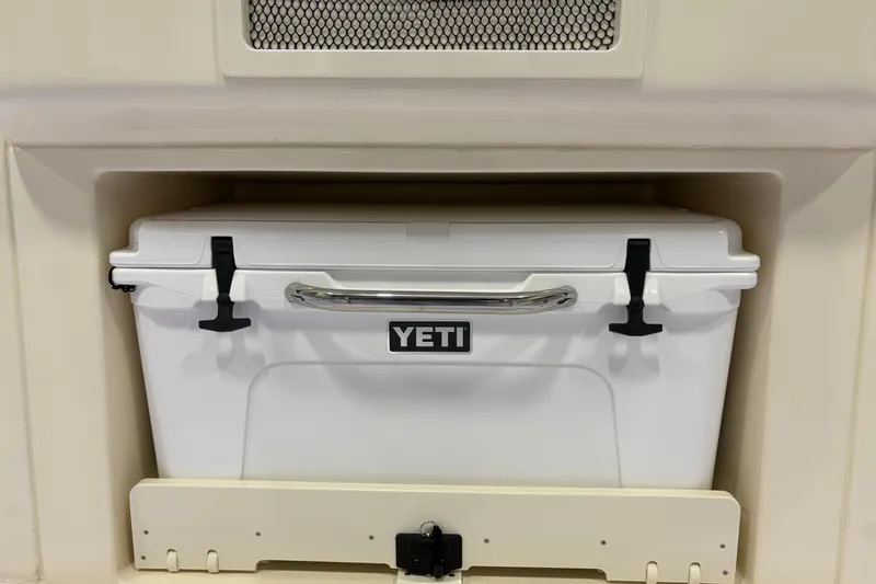 Slide: The Image of White YETI cooler stored in 2026 Scout 330 LXF boat compartment. - 22