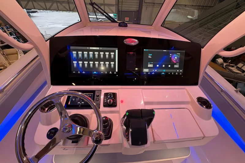 Slide: The Image of 2026 Scout 330 LXF boat dashboard with advanced touchscreen controls and steering wheel. - 26