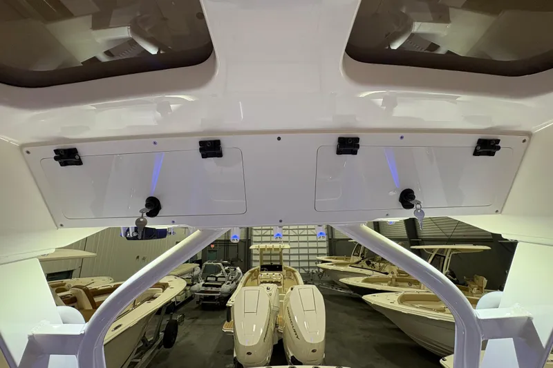 Slide: The Image of 2026 Scout 330 LXF boat interior with storage compartments and visible boat showroom. - 36