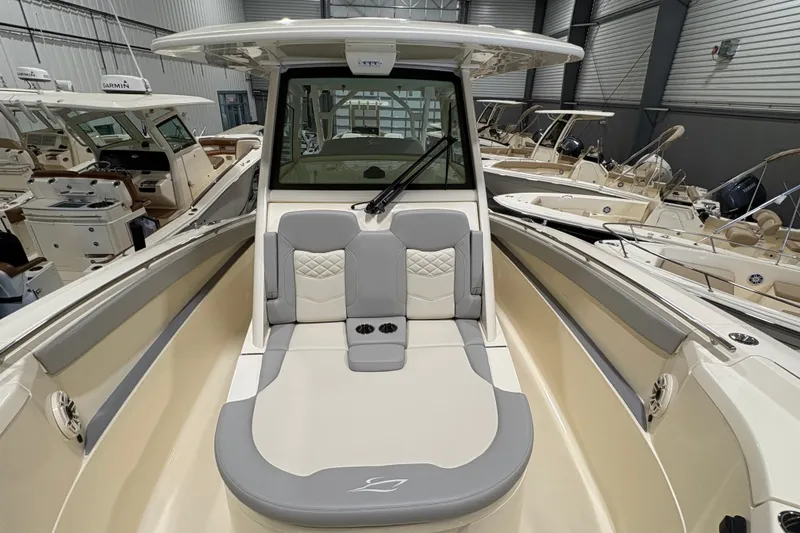 Slide: The Image of 2026 Scout 330 LXF boat interior with cushioned seating in a showroom. - 37