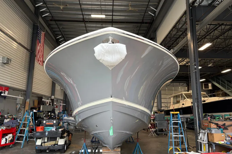 Slide: The Image of 2026 Scout 330 LXF boat displayed in a spacious indoor showroom. - 4