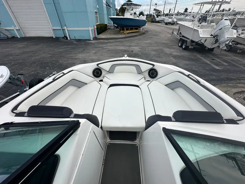 Slide: The Image of 2015 Yamaha Boats SX192 interior with white seating, docked at a marina. - 12