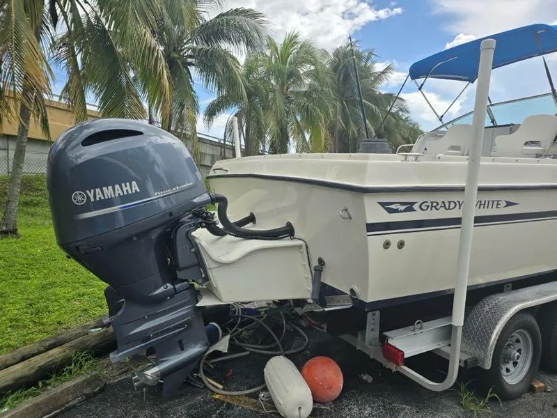Slide: The Image of 1988 Grady-White 232 Gulfstream boat with Yamaha outboard motor, parked near palm trees. - 11