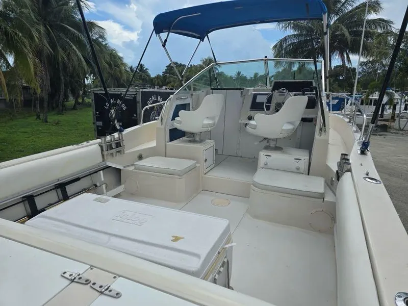 Slide: The Image of 1988 Grady-White 232 Gulfstream boat with seating, blue canopy, and open deck. - 4