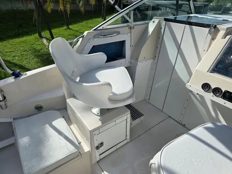 Slide: The Image of 1988 Grady-White 232 Gulfstream boat interior with white captain's chair and dashboard. - 9