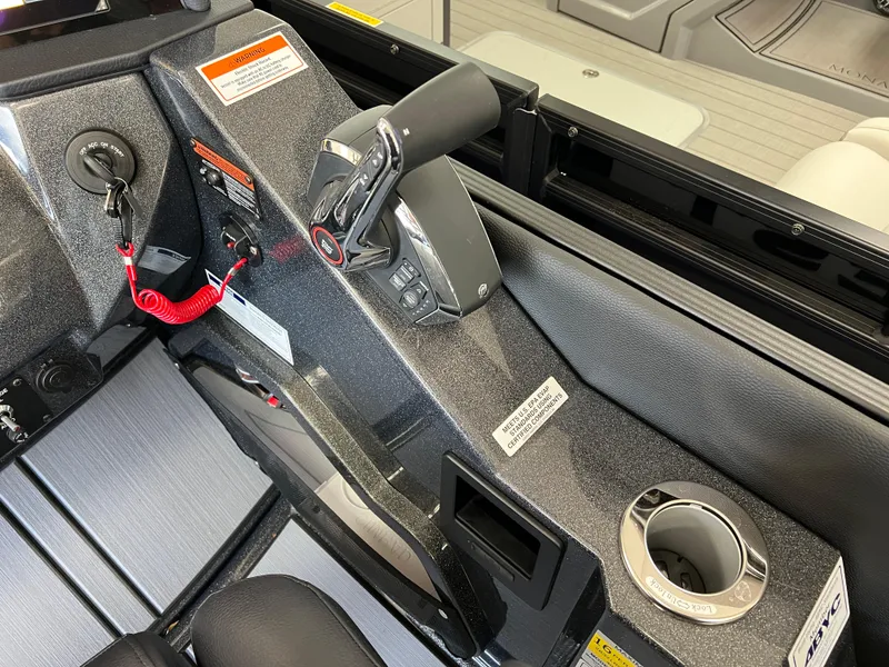 Slide: The Image of Control panel of 2025 Crest Caribbean LX 230 SLRC boat with throttle and cup holder. - 29