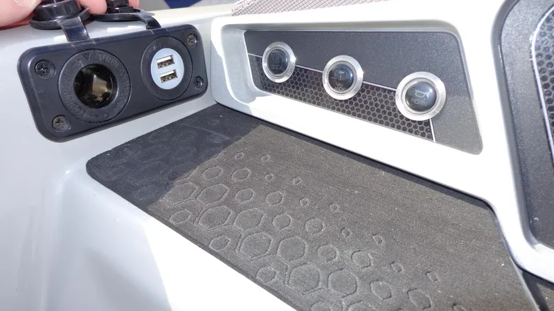 Slide: The Image of 2022 Manitou 23 SES Bench dashboard with USB ports and control buttons. - 17