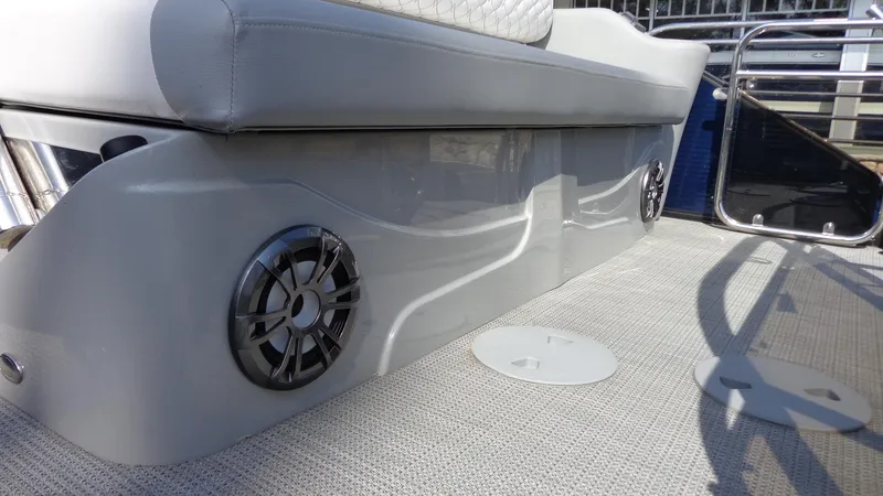 Slide: The Image of 2022 Manitou 23 SES Bench boat with built-in speakers and cushioned seating. - 7