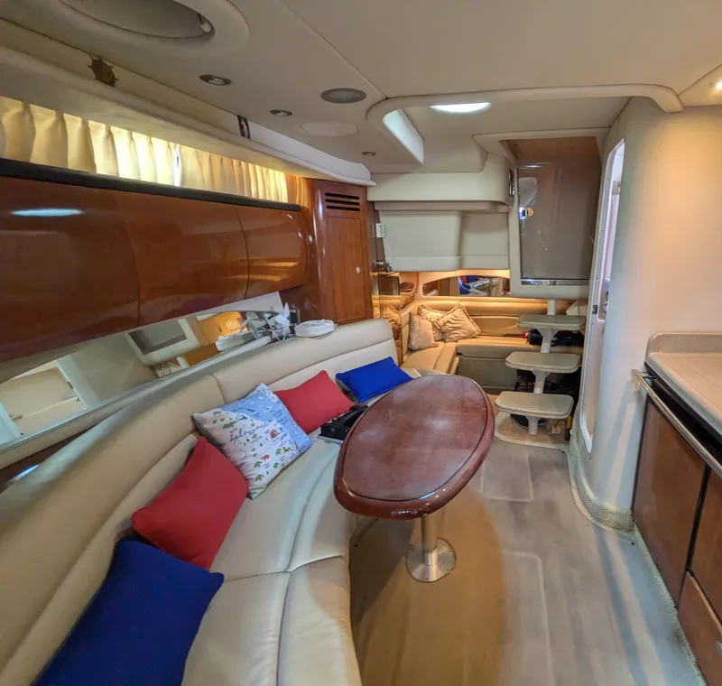 Slide: The Image of Interior of 2004 Sea Ray 360 Sundancer yacht with cozy seating and wooden accents. - 12