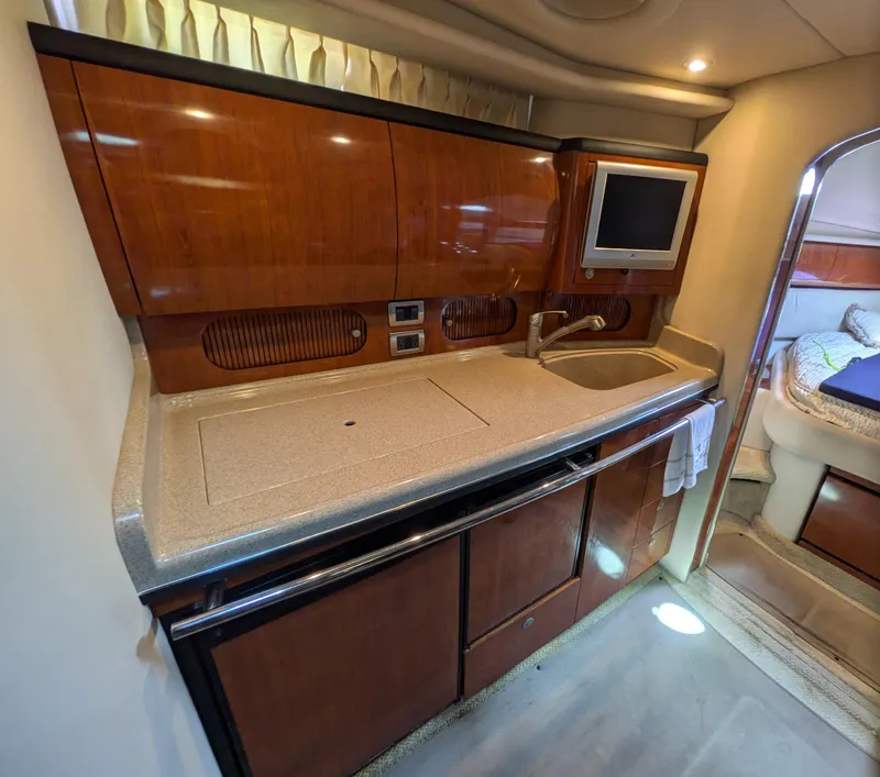 Slide: The Image of 2004 Sea Ray 360 Sundancer yacht interior with kitchenette, sink, and TV. - 13