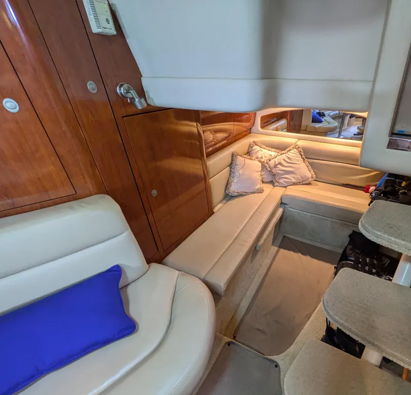 Slide: The Image of Interior of 2004 Sea Ray 360 Sundancer with beige seating and wooden cabinetry. - 14