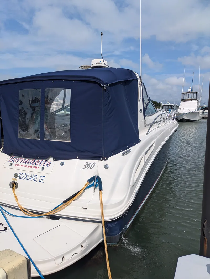 Slide: The Image of 2004 Sea Ray 360 Sundancer docked, featuring a blue canopy and sleek design. - 3