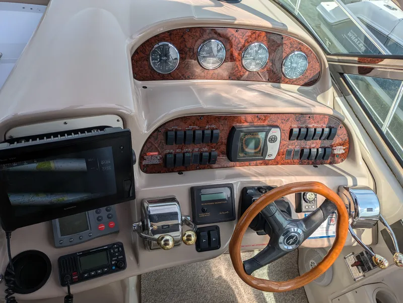 Slide: The Image of 2004 Sea Ray 360 Sundancer helm with wood accents, gauges, and steering wheel. - 8