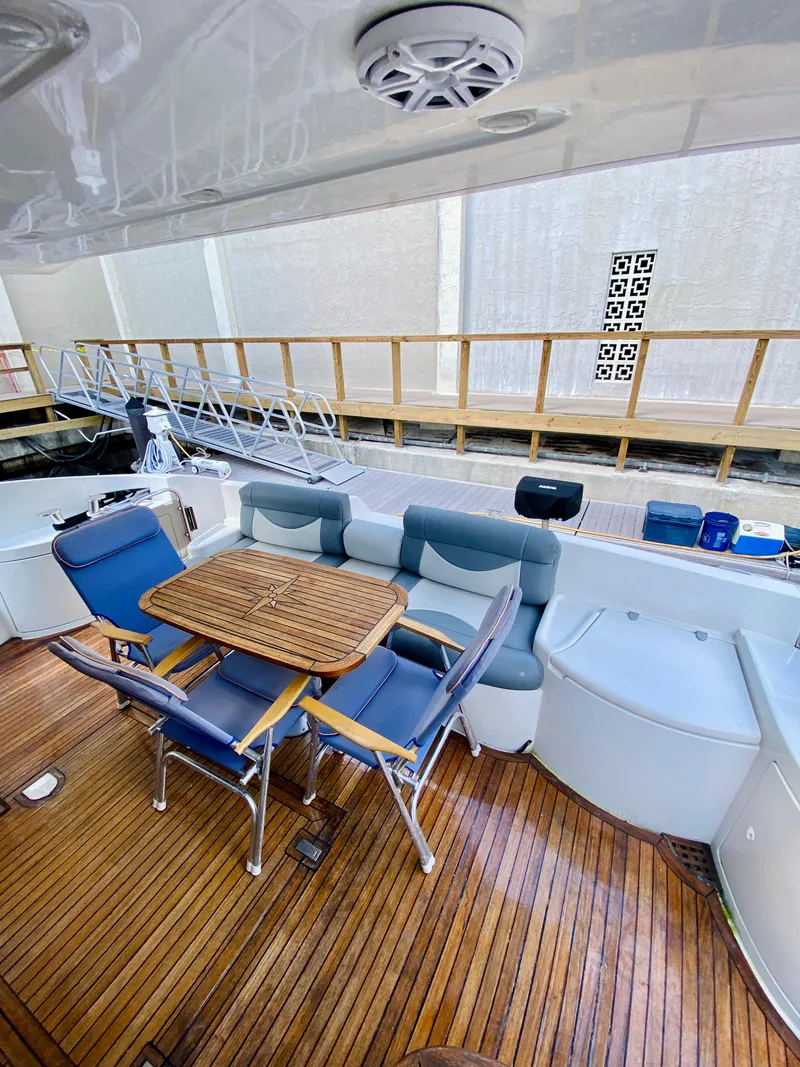 Slide: The Image of 2002 Azimut 55 yacht deck with seating and wooden table. - 11