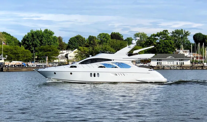 Slide: The Image of 2002 Azimut 55 yacht cruising on a serene lake with lush greenery. - 2