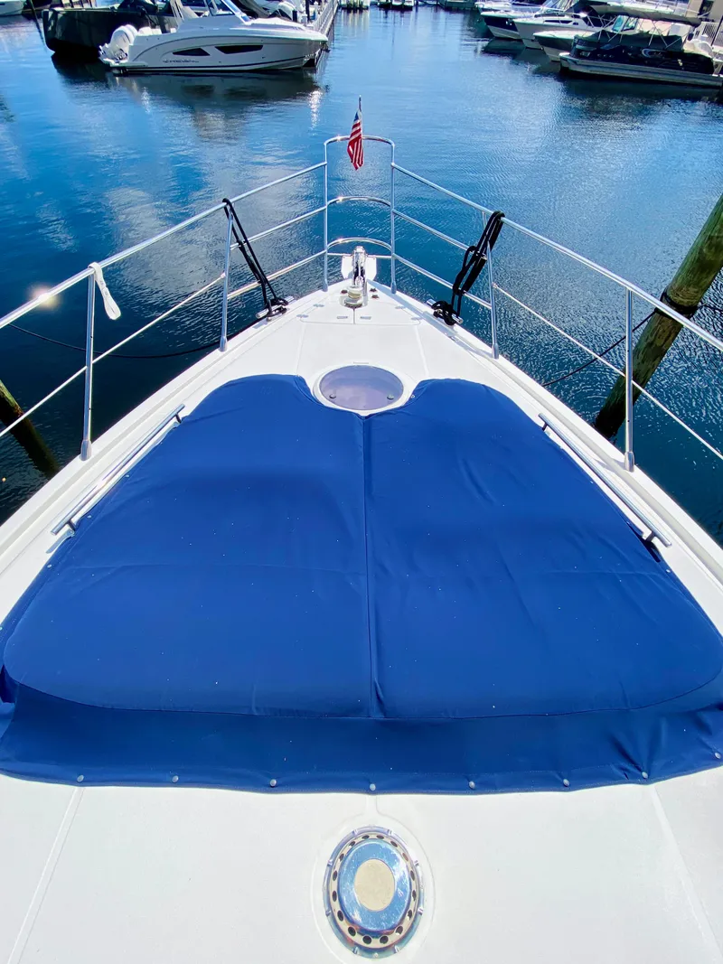Slide: The Image of Azimut 55 yacht bow with blue sunpad, docked in marina, 2002 model. - 34