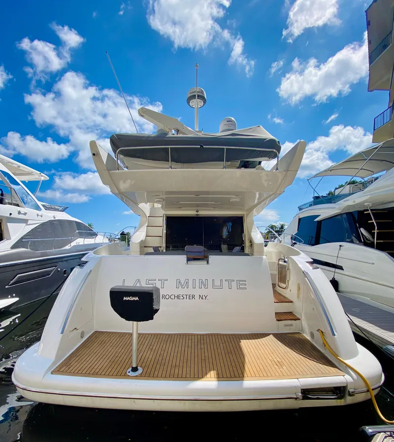 Slide: The Image of 2002 Azimut 55 yacht docked under a bright blue sky. - 5
