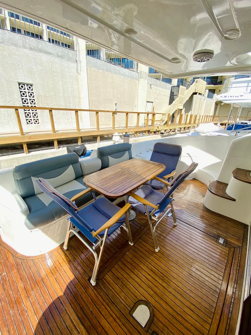 Slide: The Image of Azimut 55 2002 yacht deck with wooden flooring and outdoor seating area. - 9