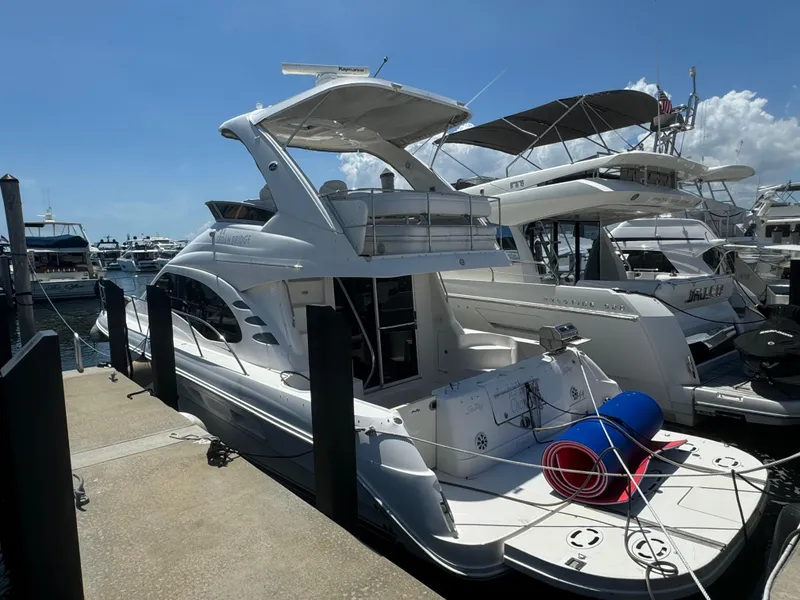 Slide: The Image of 2008 Sea Ray 44 Sedan Bridge yacht docked at marina under clear blue sky. - 1