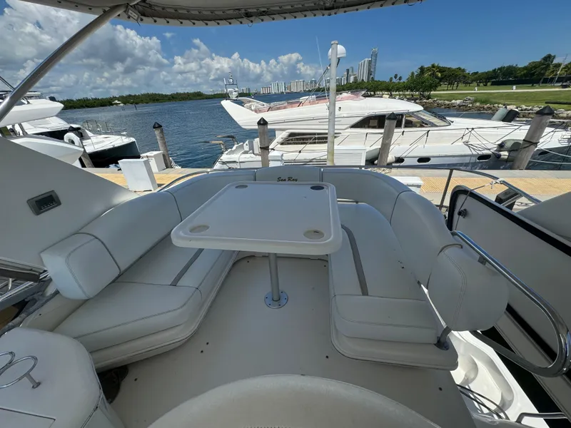 Slide: The Image of 2008 Sea Ray 44 Sedan Bridge yacht with spacious outdoor seating and table, docked by the water. - 21
