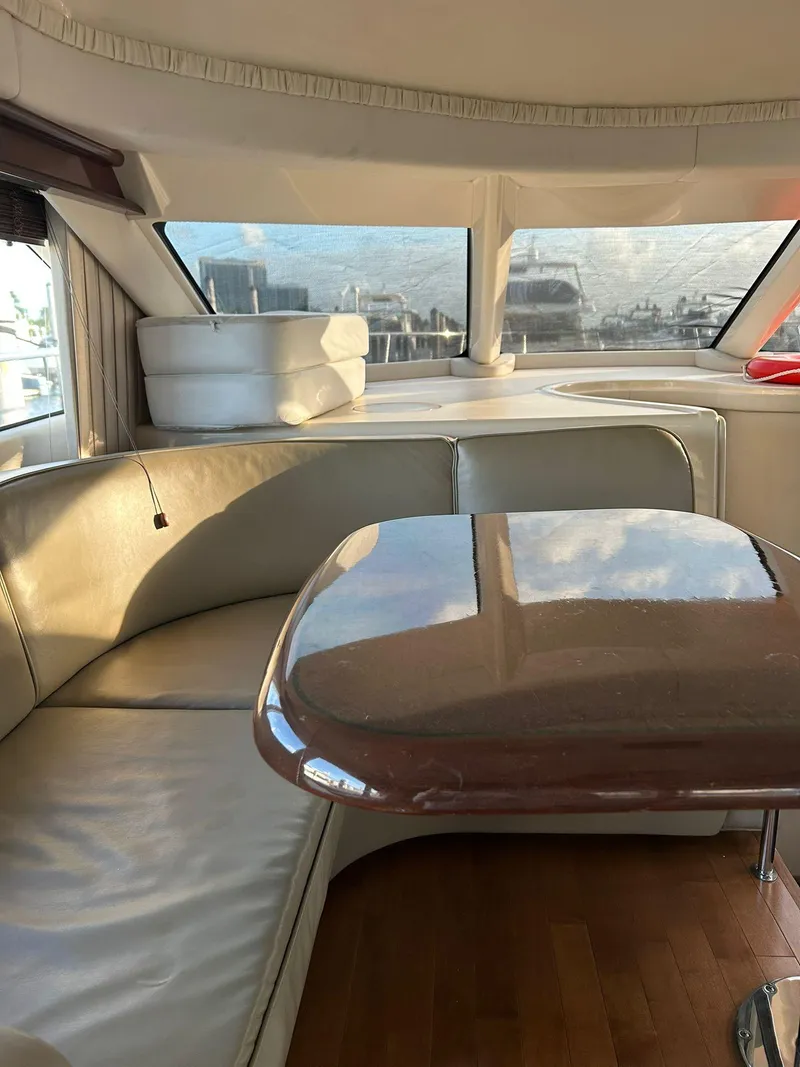 Slide: The Image of Interior of 2008 Sea Ray 44 Sedan Bridge with leather seating and wooden table. - 35