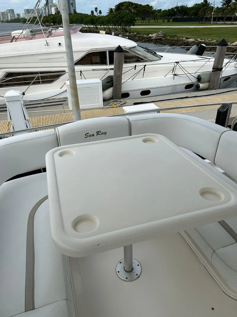 Slide: The Image of 2008 Sea Ray 44 Sedan Bridge yacht with outdoor seating and table at marina. - 45
