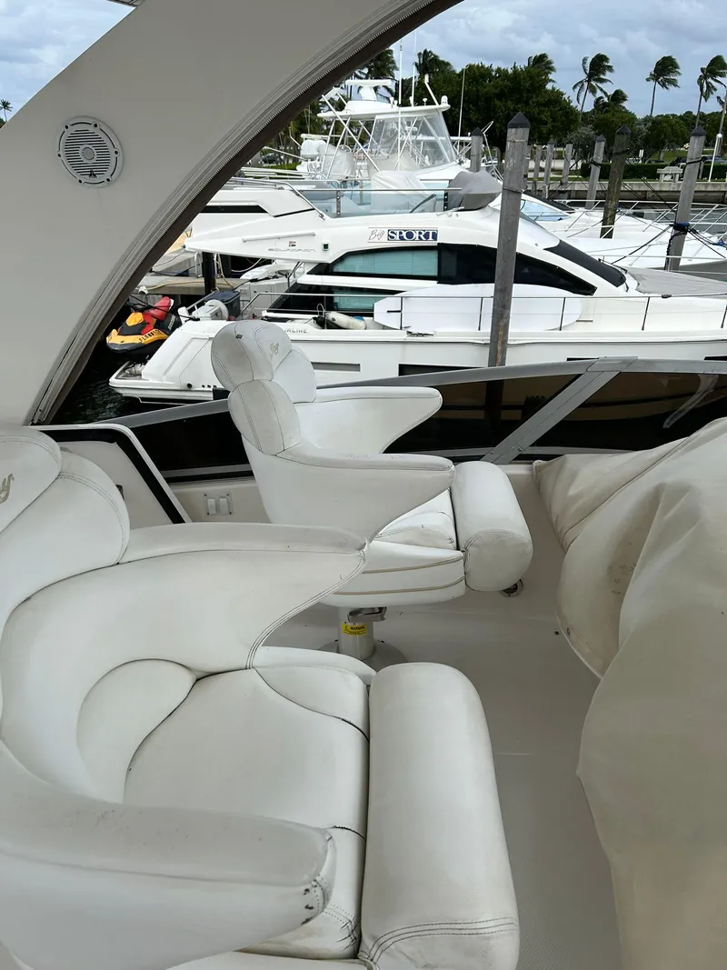 Slide: The Image of 2008 Sea Ray 44 Sedan Bridge yacht interior with white seating at marina. - 48