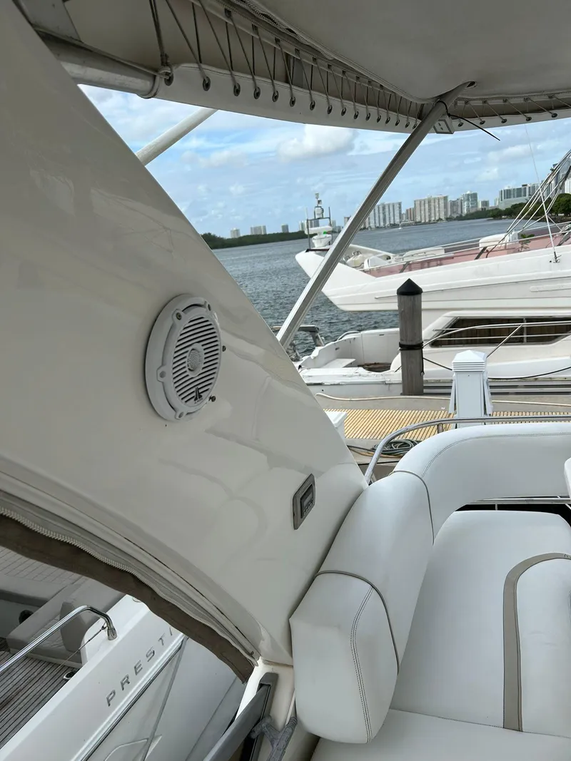 Slide: The Image of 2008 Sea Ray 44 Sedan Bridge interior with white seating and marina view. - 49