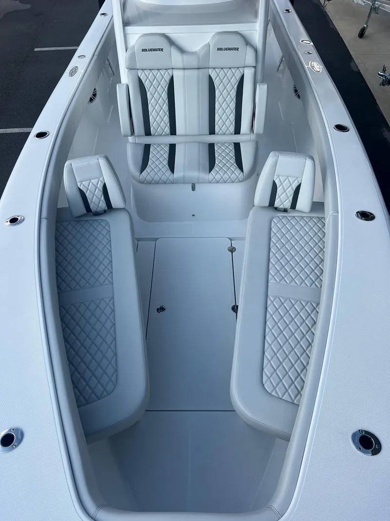 Slide: The Image of 2025 Bluewater 25 T boat interior with white quilted seating and sleek design. - 4