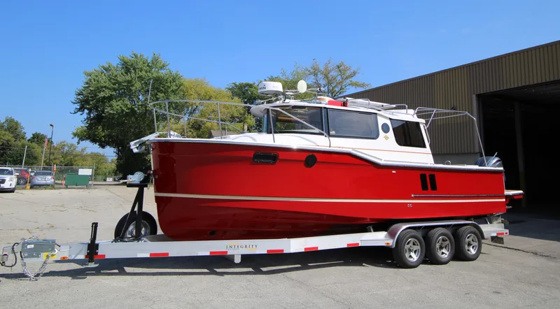 Slide: The Image of 2023 Ranger Tugs R-27 Luxury Edition boat on trailer, vibrant red exterior. - 0